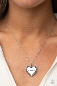 Infused with a smoky hematite rhinestone encrusted silver heart, a silver heart shaped pendant is stamped in the word, "Mom," as it swings below the collar, creating a sparkly sentimental statement piece. Features an adjustable clasp closure.

Sold as one individual necklace. Includes one pair of matching earrings.