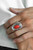 Chiseled into a tranquil marquise shape, a fiery red stone is pressed into the center of an ornate silver frame as it folds around the finger. Features a stretchy band for a flexible fit.

Sold as one individual ring.