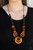 Mismatched brown and orange wooden beads are knotted in place below the collar for a seasonal look. Features an adjustable sliding knot closure.
Sold as one individual necklace. Includes one pair of matching earrings. Mismatched brown and orange wooden beads are knotted in place below the collar for a seasonal look. Features an adjustable sliding knot closure.
Sold as one individual necklace. Includes one pair of matching earrings.