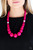 Infused with dramatic silver beads, an array of vivacious pink wooden beads drape across the chest for a summery look. Features a button-loop closure.

Sold as one individual necklace. Includes one pair of matching earrings.