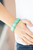 Minty Biscay Green beads are pressed into sleek silver fittings that slide along stretchy bands around the wrist, creating a vivacious pop of color.

Sold as one individual bracelet.