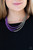 Rows of shimmery silver chain merge with shiny purple chains, creating colorful layers below the collar. Features an adjustable clasp closure.

Sold as one individual necklace. Includes one pair of matching earrings.