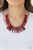 Flanked by dainty silver beads, smoky red rod-like acrylic frames are threaded along an invisible wire, creating a colorful fringe below the collar. Features an adjustable clasp closure.

Sold as one individual necklace. Includes one pair of matching earrings.