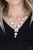 Featuring sleek gold frames, a dramatic collection of white gems cascade from the bottom of a thick gold chain. Additional gems trickle from the center, creating a glamorous extended pendant below the collar. Features an adjustable clasp closure.

Sold as one individual necklace. Includes one pair of matching earrings.