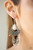 A refreshing white teardrop stone gives way to a stack of linked silver frames featuring bold tribal inspired patterns. Infused with glistening silver cube beads, a fringe of flat silver beads swing from the bottom for a flirtatiously wanderlust finish. Earring attaches to a standard fishhook fitting.
Sold as one pair of earrings. A refreshing white teardrop stone gives way to a stack of linked silver frames featuring bold tribal inspired patterns. Infused with glistening silver cube beads, a fringe of flat silver beads swing from the bottom for a flirtatiously wanderlust finish. Earring attaches to a standard fishhook fitting.
Sold as one pair of earrings.