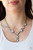 A collection of glassy white rhinestone encrusted frames link below the collar in a timeless fashion. A matching rhinestone encrusted frame and oversized white gem dangle from the bottom, creating a glamorous extended pendant. Features an adjustable clasp closure.
Sold as one individual necklace. Includes one pair of matching earrings. A collection of glassy white rhinestone encrusted frames link below the collar in a timeless fashion. A matching rhinestone encrusted frame and oversized white gem dangle from the bottom, creating a glamorous extended pendant. Features an adjustable clasp closure.
Sold as one individual necklace. Includes one pair of matching earrings.