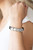 Trios of silver links are held in place with silver fittings along a rustic black leather band for an edgy urban look. Features an adjustable snap closure.

Sold as one individual bracelet.
