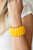 Painted in a sunny yellow finish, beveled wooden frames are threaded along stretchy bands around the wrist for a summery look.

Sold as one individual bracelet.