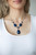 A collection of blue and white rhinestone dotted silver frames link with a pair of blue oval gems below the collar. A dramatically oversized blue teardrop drips from the center, creating a glamorous pendant. Features an adjustable clasp closure.
Sold as one individual necklace. Includes one pair of matching earrings. A collection of blue and white rhinestone dotted silver frames link with a pair of blue oval gems below the collar. A dramatically oversized blue teardrop drips from the center, creating a glamorous pendant. Features an adjustable clasp closure.
Sold as one individual necklace. Includes one pair of matching earrings.