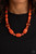 Varying in size and shape, a hearty collection of glassy, hammered, and polished orange beads are threaded along an invisible wire below the collar. Dainty silver beads and discs are sprinkled along the colorful collaboration for a shimmery finish. Features an adjustable clasp closure.

Sold as one individual necklace. Includes one pair of matching earrings.