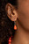 Varying in size and shape, a hearty collection of glassy, hammered, and polished orange beads are threaded along an invisible wire below the collar. Dainty silver beads and discs are sprinkled along the colorful collaboration for a shimmery finish. Features an adjustable clasp closure.

Sold as one individual necklace. Includes one pair of matching earrings.