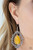 A teardrop yellow cat's eye stone swings from the top of an ornately white rhinestone encrusted frame, creating an icy lure. Earring attaches to a standard fishhook fitting.

Sold as one pair of earrings.