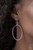 Encrusted in glassy pink rhinestones, an airy silver hoop swings from the ear for a refined fashion. Earring attaches to a standard fishhook fitting.

Sold as one pair of earrings.