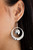 A hammered shiny copper or silver disc swings from the top of a hammered shiny copper or silver hoop that widens at the bottom, creating a radiant lure. Earring attaches to a standard fishhook fitting.

Sold as one pair of earrings.