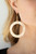 A flat gold circular frame has been hammered in blinding detail for a handcrafted look. Earring attaches to a standard fishhook fitting.

Sold as one pair of earrings.