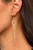 Infused with a sparkly strand of glassy white rhinestones, tapered strands of dainty gold ball chain stream from the bottom of a white rhinestone encrusted ring for a glamorously glittery look. Earring attaches to a standard fishhook fitting.
Sold as one pair of earrings. Infused with a sparkly strand of glassy white rhinestones, tapered strands of dainty gold ball chain stream from the bottom of a white rhinestone encrusted ring for a glamorously glittery look. Earring attaches to a standard fishhook fitting.
Sold as one pair of earrings.