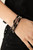 Infused with faceted silver beads, a glamorous collection of sparkly black crystals and smoky beads are threaded along stretchy bands around the wrist, creating glittery layers.

Sold as one set of three bracelets.