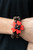 Featuring heart-shaped petals, a bright red wooden flower sits atop double strands of wooden beads threaded along stretchy bands for a tropical flair atop the wrist.

Sold as one individual bracelet.