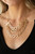Three rows of gold chains with oversized hammered oval links attach to gold bars for an edgy display below the collar. Features an adjustable clasp closure.

Sold as one individual necklace. Includes one pair of matching earrings.