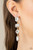 A strand of oversized round, teardrop, and emerald cut white rhinestones trickles from the ear, creating a jaw-dropping golden chandelier. Earring attaches to a standard post earring.

Sold as one pair of post earrings.
