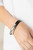 Curved silver rectangular frames glide along two dainty strands of black leather, creating edgy layers around the wrist. Features a magnetic closure.

Sold as one individual bracelet.