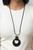 A large cutout silver disc, overlaid with black leather, is cradled in a wide black leather strap. The luxe pendant sways from a U-shaped silver cylinder threaded along the end of a lengthened polished black cord for an indulgently lavish finish. Features a sliding bead closure.
Sold as one individual necklace. Includes one pair of matching earrings. A large cutout silver disc, overlaid with black leather, is cradled in a wide black leather strap. The luxe pendant sways from a U-shaped silver cylinder threaded along the end of a lengthened polished black cord for an indulgently lavish finish. Features a sliding bead closure.
Sold as one individual necklace. Includes one pair of matching earrings.