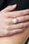 A white opalescent bead flecked with shimmering glitter is encased in a simple round silver frame creating a dazzling centerpiece atop the finger. Features a dainty stretchy band for a flexible fit.

Sold as one individual ring.