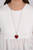 Bordered in glassy white rhinestones, an oversized red heart gem sparkles from the bottom of an extended silver chain for a flirty finish. Features an adjustable clasp closure.

Sold as one individual necklace. Includes one pair of matching earrings.