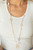 Asymmetrical hammered gold frames and imperfect pearly accents link with sections of classic gold chains across the chest, creating a rustic and refined statement piece. A lobster clasp hangs from the bottom of the design to allow a name badge or other item to be attached. Features an adjustable clasp closure.
Sold as one individual lanyard. Includes one pair of matching earrings. Asymmetrical hammered gold frames and imperfect pearly accents link with sections of classic gold chains across the chest, creating a rustic and refined statement piece. A lobster clasp hangs from the bottom of the design to allow a name badge or other item to be attached. Features an adjustable clasp closure.
Sold as one individual lanyard. Includes one pair of matching earrings.