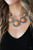 Earthy orange stones, pressed into round antiqued silver frames featuring dot and interlinking loop motifs, create a dramatically rustic statement as they link across the collar. Features an adjustable clasp closure.

Sold as one individual necklace. Includes one pair of matching earrings.