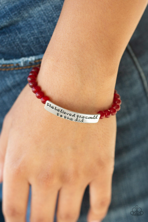 A collection of dainty red cats eye stone beads and an antiqued frame stamped in the inspirational phrase, She believed she could, so she did, are threaded along a stretchy band around the wrist for a whimsical fashion.

Sold as one individual bracelet.