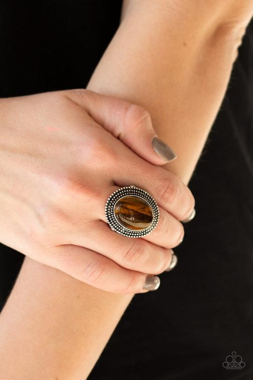 A polished Tiger's Eye stone is pressed into the center of a shimmery silver frame radiating with studded textures. As the stone elements in this piece are natural, some color variation is normal. Features a stretchy band for a flexible fit.

Sold as one individual ring.