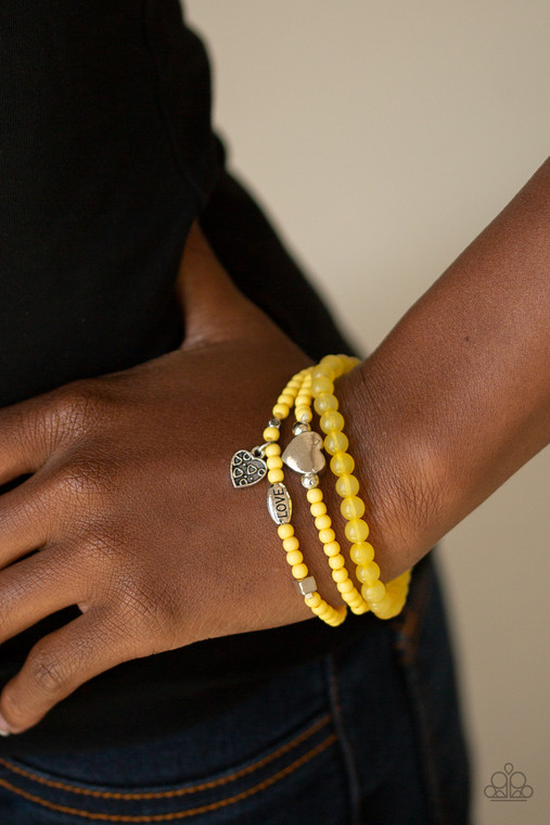 An array of glassy and polished yellow beads are threaded along stretchy bands. Infused with silver accents, a collection of silver heart charms and a bead spelling out the word, "love", adorn the beaded strands for a romantic finish.

Sold as one set of three bracelets.