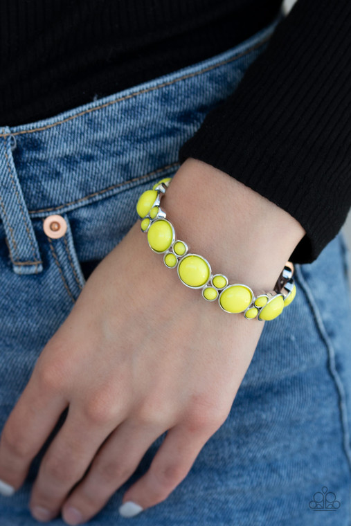 Clustered yellow beaded frames are threaded along stretchy bands around the wrist, creating a bubbly look.

Sold as one individual.