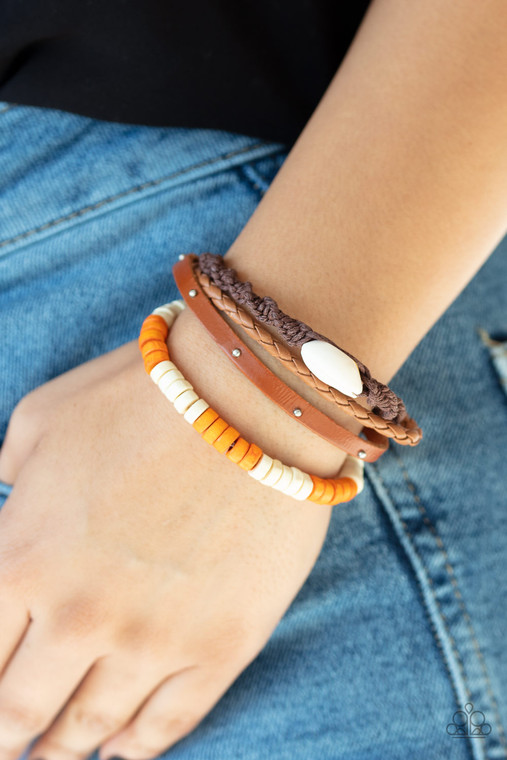 Featuring a collection of colorful wooden beads, shiny studs, and a white shell, mismatched leather and twine strands layer across the wrist for a beach inspired look. Features an adjustable sliding knot closure.

Sold as one individual bracelet.