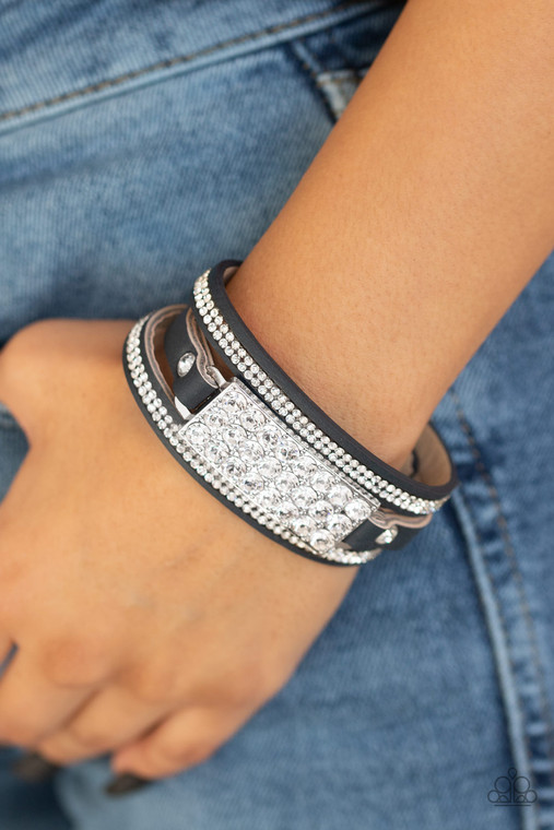 A thick blue leather band is spliced into three separate strands. Encrusted in rows of glassy white rhinestones, two glittery strands flank a blinding silver buckle encrusted in oversized white rhinestones for a glamorous finish. Features an adjustable snap closure.

Sold as one individual bracelet.