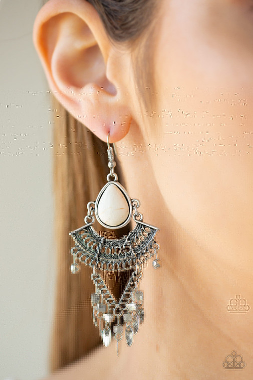 A refreshing white teardrop stone gives way to a stack of linked silver frames featuring bold tribal inspired patterns. Infused with glistening silver cube beads, a fringe of flat silver beads swing from the bottom for a flirtatiously wanderlust finish. Earring attaches to a standard fishhook fitting.

Sold as one pair of earrings.