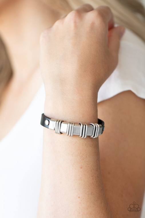 Trios of silver links are held in place with silver fittings along a rustic black leather band for an edgy urban look. Features an adjustable snap closure.

Sold as one individual bracelet.