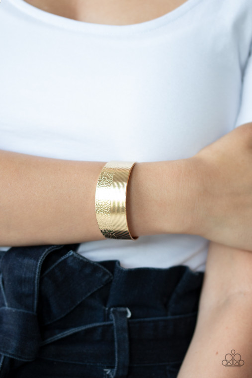 One half of a thick gold cuff is engraved in stacked linear lines while the other half is hammered in a row of tactile textures, creating a collision of texture around the wrist.

Sold as one individual bracelet.