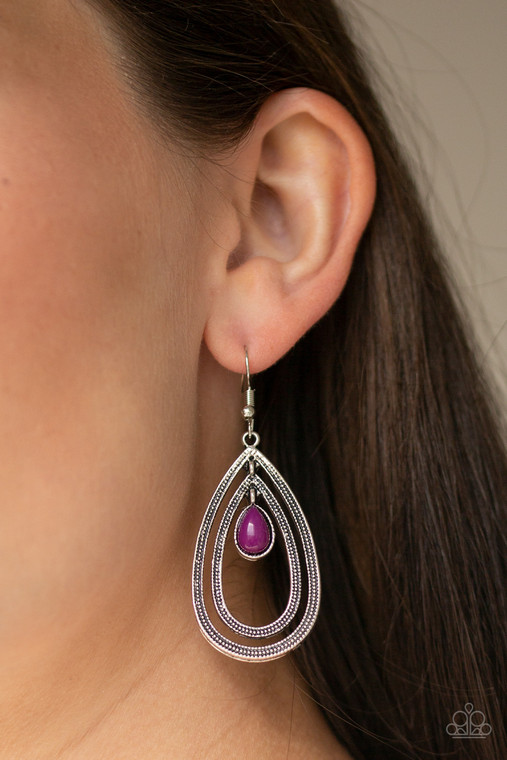 A purple teardrop bead is nestled inside two silver teardrops radiating in studded textures, creating a dizzying lure. Earring attaches to a standard fishhook fitting.

Sold as one pair of earrings.