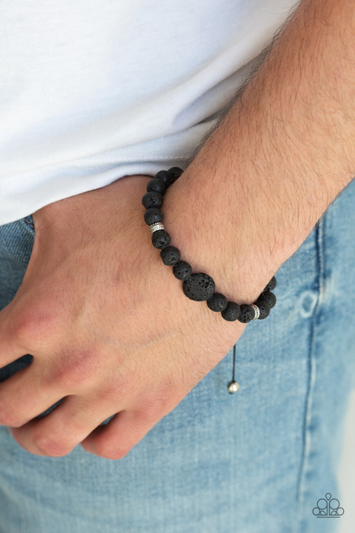 Infused with dainty silver beads, a collection of earthy black lava rock beads are threaded along a shiny cord around the wrist for a seasonal look. Features an adjustable sliding knot closure.