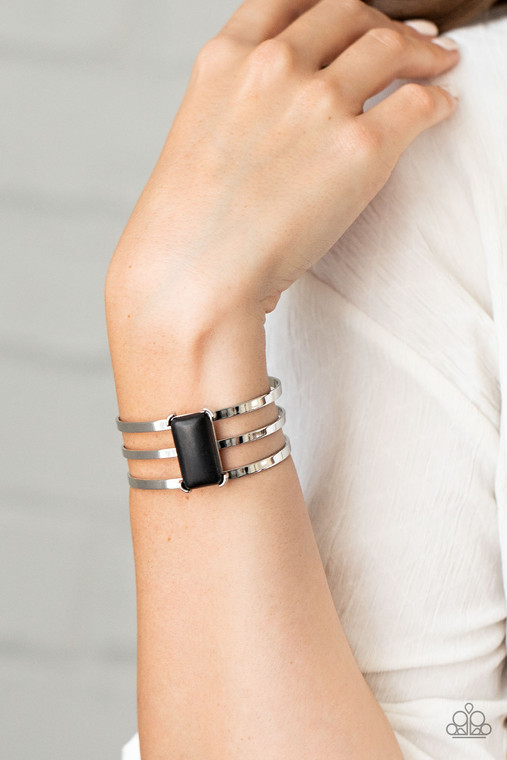 Chiseled into a sleek rectangle, a smooth black stone is pressed into the center of a silver layered cuff for a seasonal flair.

Sold as one individual bracelet.