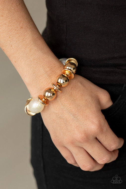 A glamorous collection of oversized gold beads and iridescent oval shaped beads are threaded along a stretchy band around the wrist for a gorgeous effect. The iridescent beads feature a subtle scratch surface, adding shimmer to the refined display.

Sold as one individual bracelet.