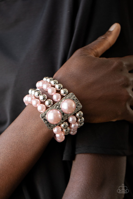 Held in place with a hammered silver frame dotted with two oversized pink pearls, strands of classic silver and pearly pink beads are threaded along stretchy bands around the wrist for a glamorously layered look.

Sold as one individual bracelet.