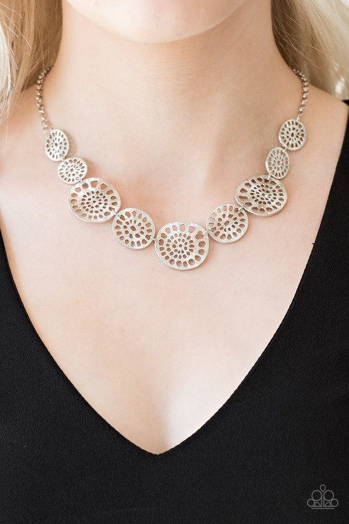 Featuring airy stenciled patterns, shimmery silver discs link below the collar for a whimsical asymmetrical look. Features an adjustable clasp closure.

Sold as one individual necklace. Includes one pair of matching earrings.