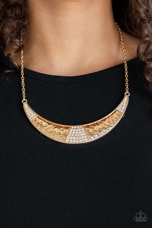 Featuring a shimmery hammered finish, a glistening gold half-moon plate is encrusted in sections of glassy white rhinestones, creating a blinding statement piece below the collar. Features an adjustable clasp closure.

Sold as one individual necklace. Includes one pair of matching earrings.