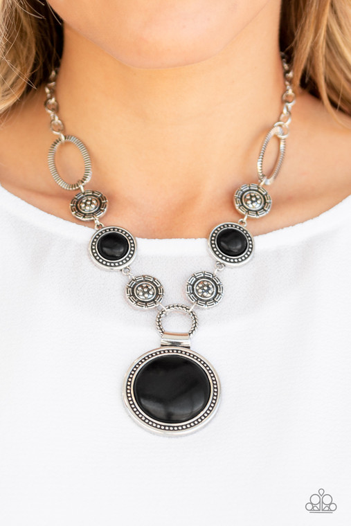 Featuring floral, textured, and earthy black stone accents, a collection of unique silver frames link below the collar for a seasonal flair. A dramatically oversized black stone pendant dangles from the bottom for an eye-catching finish. Features an adjustable clasp closure.

Sold as one individual necklace. Includes one pair of matching earrings.