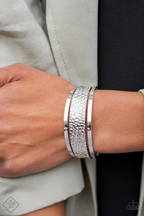 A silver cuff embossed in metallic crocodile-like print is flanked by two sleek silver bars, creating an airy silver cuff for a wildly stacked look.

Sold as one individual bracelet.