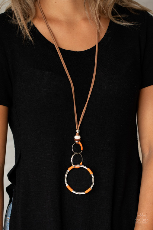 Wrapped in sections of orange threaded accents, a mismatched trio of hammered silver rings link at the bottom of a beaded fitting. The earthy compilation is attached to lengthened strands of brown suede for an authentic finish. Features an adjustable clasp closure.

Sold as one individual necklace. Includes one pair of matching earrings.
