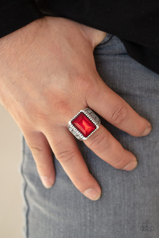 Featuring a regal emerald style cut, a glittery red gem is pressed into a textured silver frame featuring a thick silver band embossed in bold tribal inspired textures. Features a stretchy band for a flexible fit.

Sold as one individual ring.